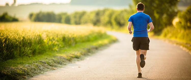 photo of man running along path on a sunny day