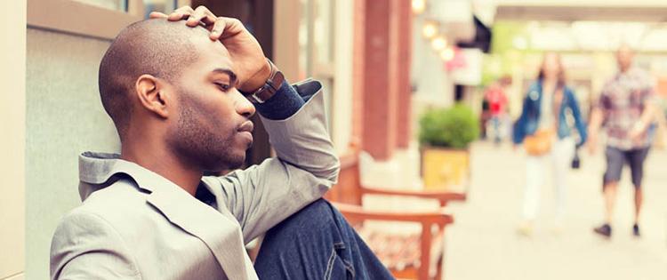 man sitting with hand resting on head