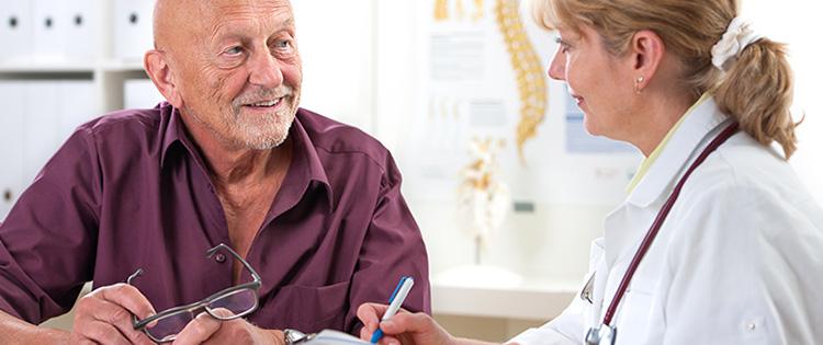 Doctor discussing information with elderly, male patient