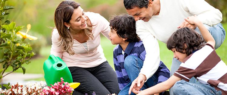 A family with a mother, father, and two young boys sitting outside.