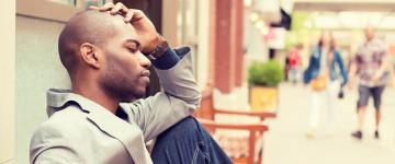 man sitting with hand resting on head