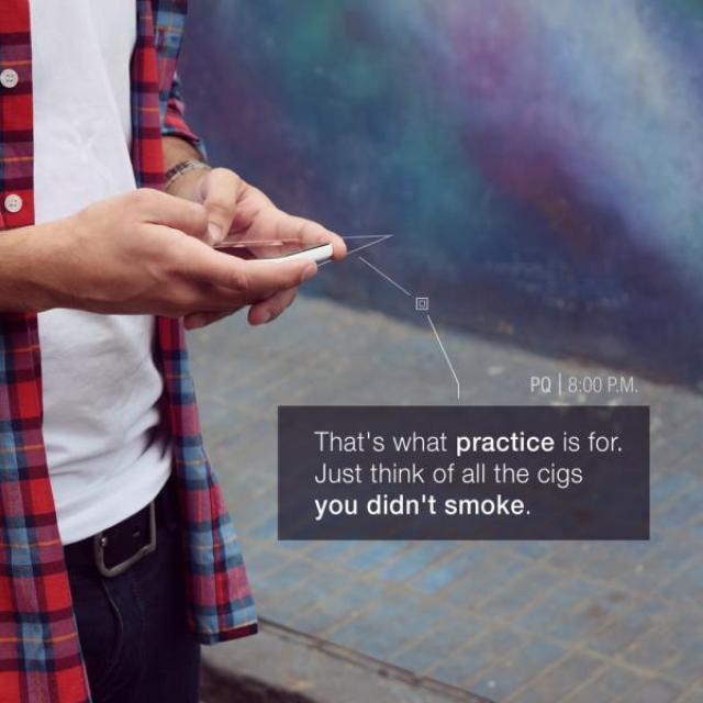 A close up of a person texting on their phone, with the message, "That's what practice is for. Just think of all the cigs you didn't smoke."
