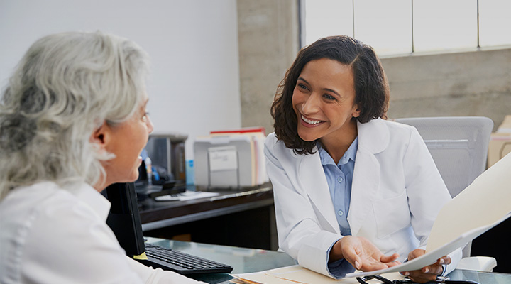 Una doctora hablando con un paciente.